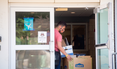 Student moving into residence halls wearing mask