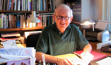 Thomas Mickey sits at a desk