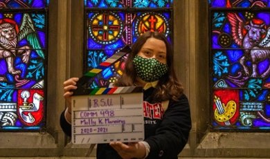 Molly Manning holds a director's clapboard