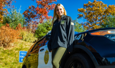 Sarah Carlozzi stands in front of a police cruiser
