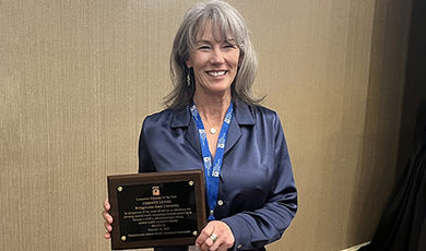 Christy Lyons holds her counselor educator of the year plaque.