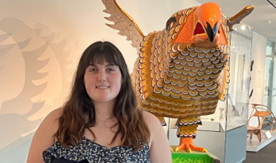 Brie stands in front of a bird sculpture at a local museum 