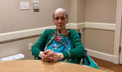 Ruth Calhoun poses for a photo sitting at a table.