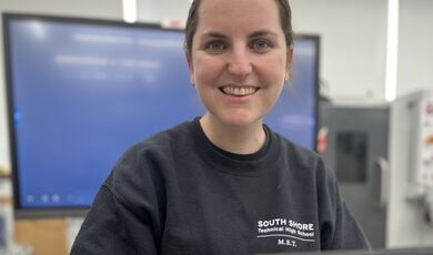 A woman wearing a black shirt smiles at the camera