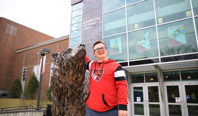 CJ standing next to the bear statue in front of the RSU 