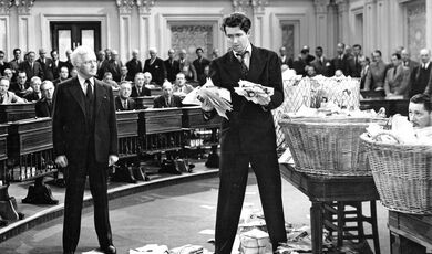 Promotional still from the 1939 film Mr. Smith Goes to Washington showing James Stewart holding piles of letters on the floor of the Senate