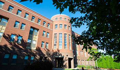 The front of DiNardo Hall with branches of a tree in the foreground