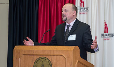 Dr. Brian Frederick speaks at a podium.