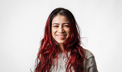 A woman with long hair smiles at the camera