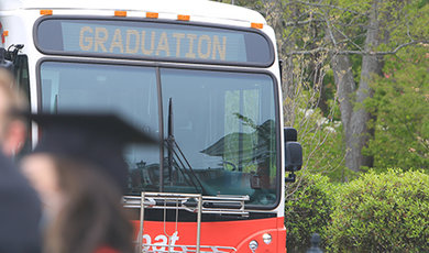 A BSU Transit bus displays a graduation sign.