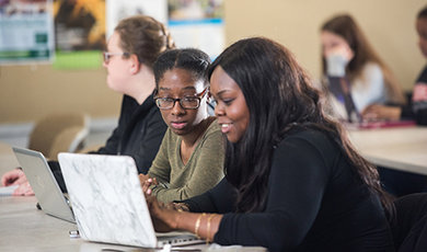 Two students work together at a desk