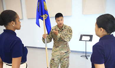 Sean Kelly holds a flag as part of a ROTC activity