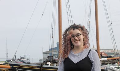 Carolyn King stands in front of an old whaling ship.