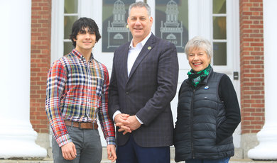 Peter Koutoujian, '25, Peter J. Koutoujian, '83 and Connie Koutoujian stand on steps of Boyden Hall 