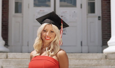 Kristina Picarski poses for a photo in her graduation cap in front of Boyden Hall.