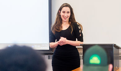 Sidita Kushi teaches a class in front of a white board.