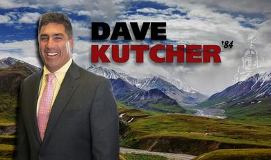 Dave Kutcher wears a suit with alaskan background 