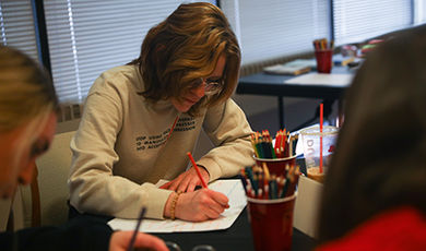 A student uses colored pencils to draw a mind map during a Life Design workshop.