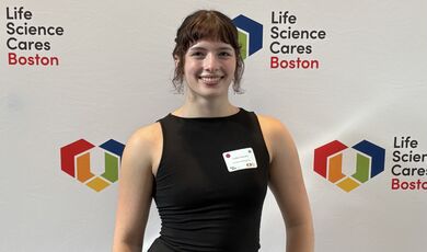A woman wearing a black dress smiles