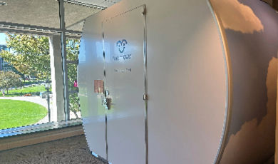 A white lactation pod sits next to a window 