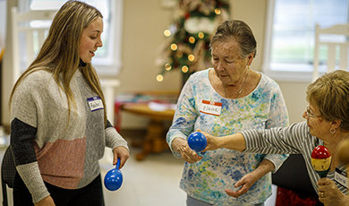 A student and seniors shake maracas.