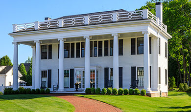Exterior of a white house with columns along its front.