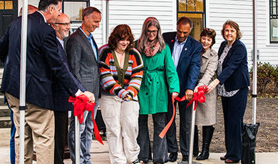 Jane Richard cuts a red ribbon in front of the Martin Richard Institute for Social Justice's new home/