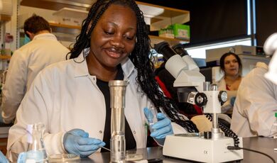 A student works with a microscope in a lab.