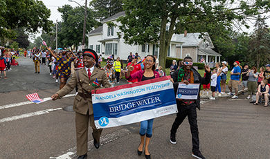 Mandela fellows carry a banner announcing the fellowship in the parade.