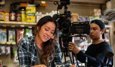 Patty Lee on the set of a tv show with a cameraman standing behind her 