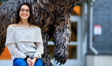 Paulina Aguilar sits in front of bear statue on BSU campus