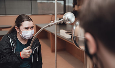 Students conduct a demonstration using a Van de Graaff generator.