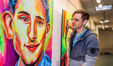 Bry Sharland looks at one of his portraits hung in a gallery.