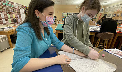 Kristyn Shea works with a student who is drawing.