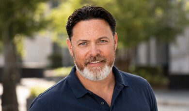 Headshot of Weston Smith in front of a street lined with trees