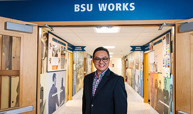 Gerald Tang stands in a hallway below a BSU Works sign