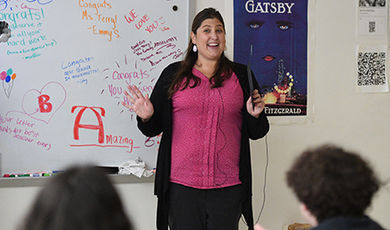 Shelley Terry teaches her class with congratulatory messages on the white board behind her.