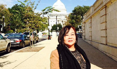 My Lan Tran stands o a sidewalk in front of the U.S. Capitol.