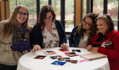 Students look at portraits on a table during Truth Tellers event