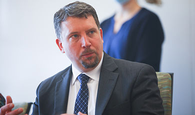 Steve Zuromski converses while sitting at a table.