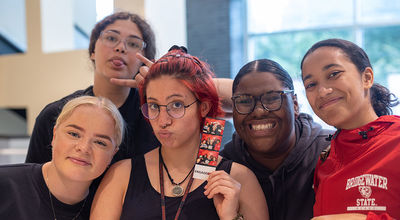 Five student leaders smile for the camera at the BSU involvement fair.