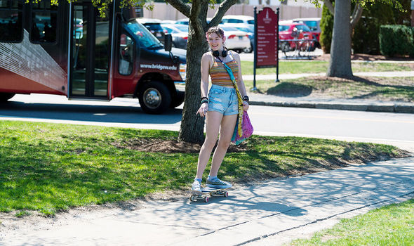 A student skateboarding on campus