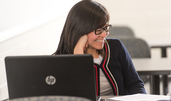 student smiling on laptop