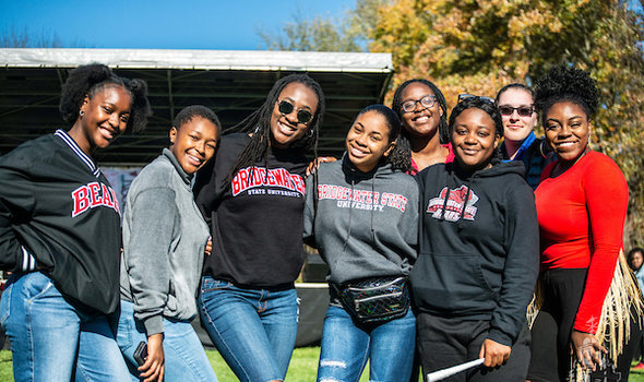 diverse group of students smile and post together