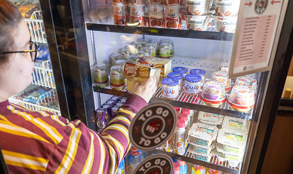 A student grabbing a Snack Pack from a Bears To Go fridge
