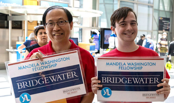 Dr. Wing-kai To and Vincent Pellegrino holding up Bridgewater signs to greet the Fellows at Logan Airport