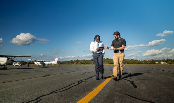 a BSU flight instructor talks with a BSU aviation student on the tarmac at the New Bedford airport