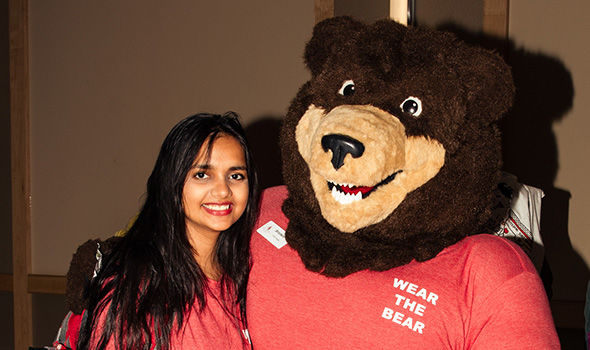A student poses with Bristaco, BSU's Bear mascot, at Casino Night