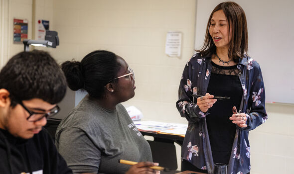 Dr. Minae Yamamoto Savas speaking to a student in her Calligraphy class