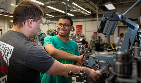 2 students working with equipment in a machine shop at South Shore Regional Voc Tech High School
